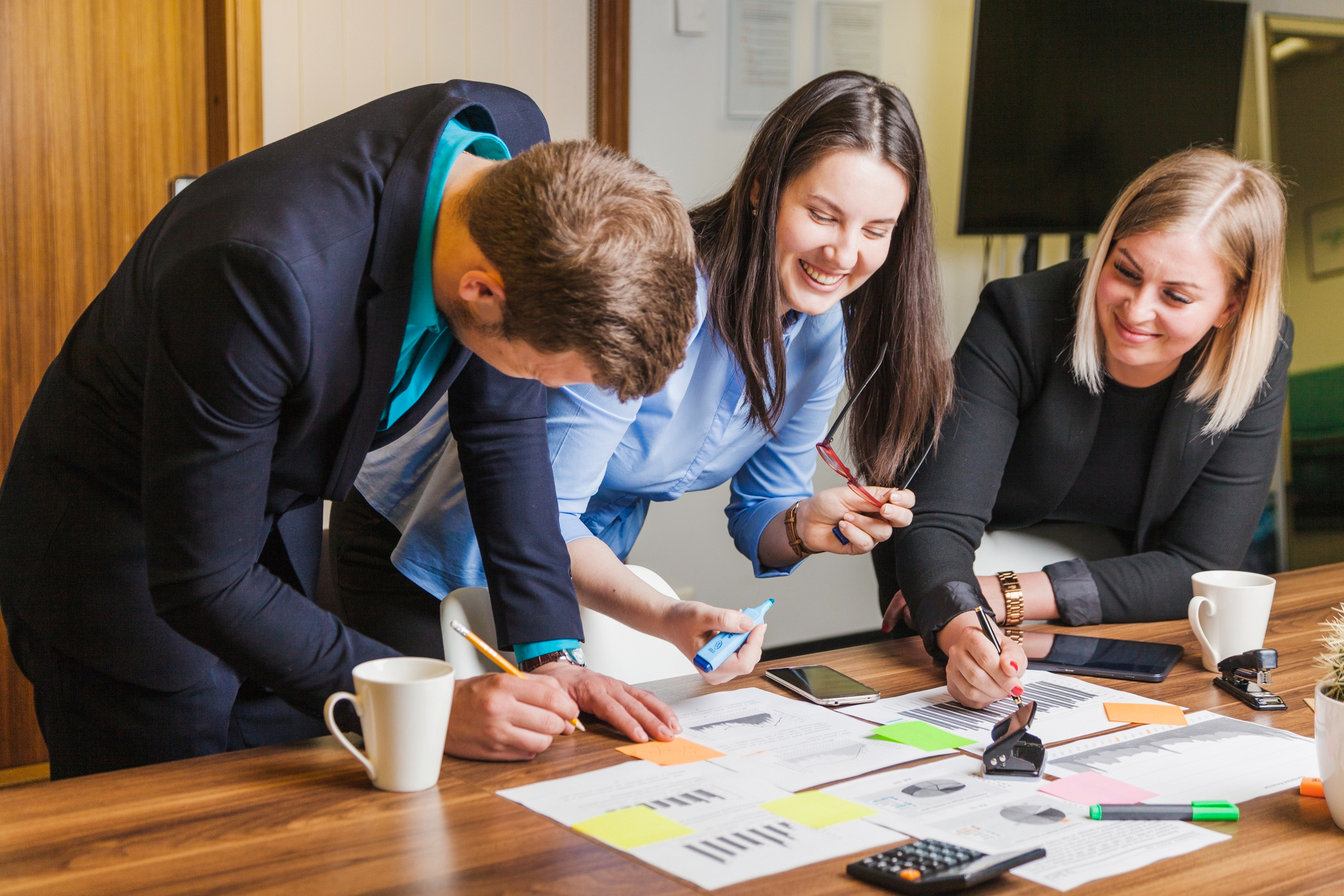 A professional office environment reflecting the core values and mission of an accounting company. The image should depict an organized workspace with a clean desk featuring accounting-related items such as documents, calculators, and a laptop. In the background, there can be a soft focus on a team of professionals collaborating, symbolizing expertise and teamwork. The scene conveys trust, reliability, and a commitment to high-quality financial services, aligned with the company's mission and focus on providing accounting solutions in Kazakhstan.